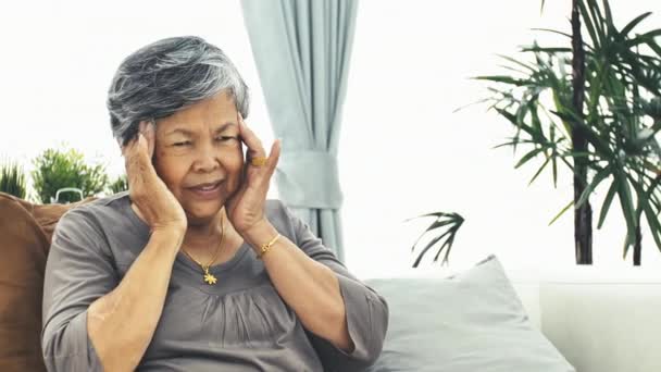 頭痛を持つ高齢女性とアジアの成熟した女性は 錠剤を取ります 4Kスローモーション — ストック動画