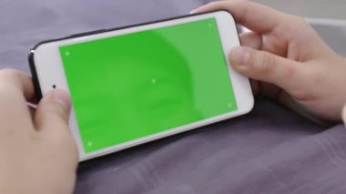 Dolly atış çocuğun bir telefon için Chroma anahtar mockup yeşil bir ekran ile elinde tutuyor. 4 k yeşil ekran