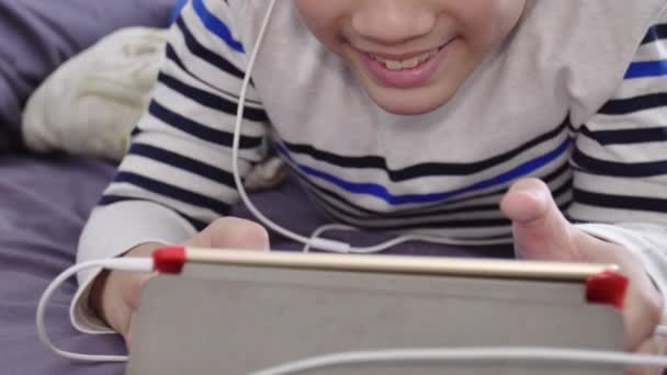Tablet Bilgisayarda Izlemek Gülümsemek Yüz Beyaz Kulaklık Giyen Asya Yakışıklı — Stok video