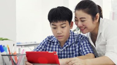 Anne ve oğlu oynamak ve smartphone, izlerken mutlu Asya ailesi ile gülen yüz evde çekim Dolly .