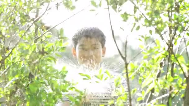 晴れた暑い日にアジアの男の子の4Kハンドヘルド 男の子は水で遊んで 水で非常に入浴を楽しんでいます その少年はとても幸せで微笑んでいる — ストック動画