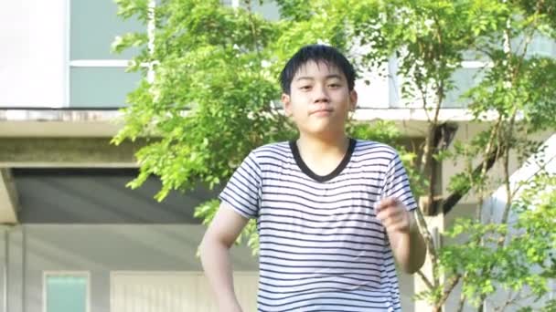 手持式 亚洲男孩跳舞和玩水的肖像 享受它非常与水沐浴 男孩在家里的花园里很开心 面带微笑 — 图库视频影像