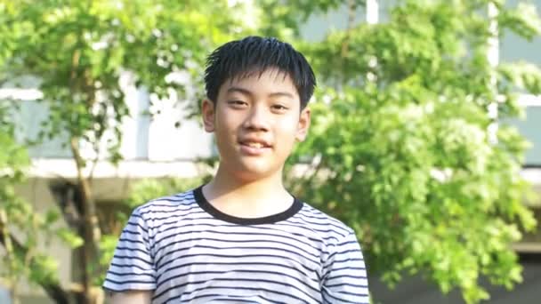 ハンドヘルド ダンスし水と遊ぶ それを楽しんでアジアの少年の肖像非常に水で入浴 少年は自宅の庭で非常に幸せと笑顔をします — ストック動画