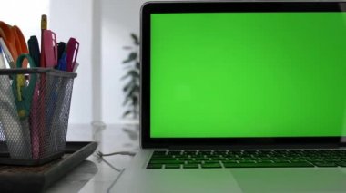 Yeşil Renk Anahtar Ekranı Gösteren Dizüstü Bilgisayar Oturma Odasında Bir Masa Üzerinde Duruyor. Arka Planda Rahat Oturma Odasında. Dolly Soldan sağa vurulmuş. 4k