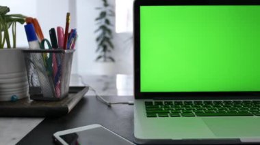 Yeşil Renk Anahtar Ekranı Gösteren Dizüstü Bilgisayar Oturma Odasında Bir Masa Üzerinde Duruyor. Arka Planda Rahat Oturma Odasında. Dolly Soldan sağa vurulmuş. 4k