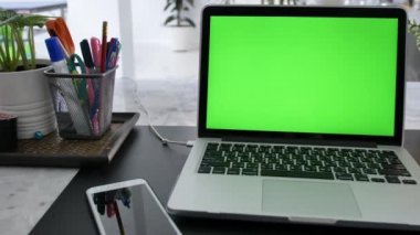 Yeşil Renk Anahtar Ekranı Gösteren Dizüstü Bilgisayar Oturma Odasında Bir Masa Üzerinde Duruyor. Arka Planda Rahat Oturma Odasında. Dolly Soldan sağa vurulmuş. 4k