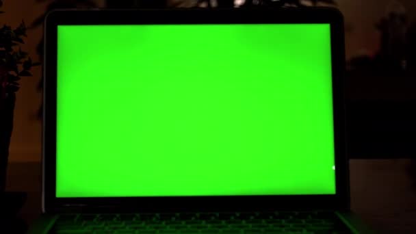 显示绿色色度键屏幕的笔记本电脑矗立在客厅的办公桌上 在背景舒适的客厅在晚上与温暖的灯打开 放大缩小字体功能 放大缩小字体功能4K — 图库视频影像