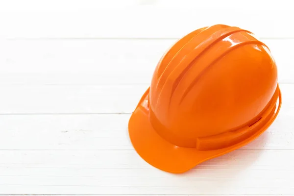 Ingegnere o caposquadra casco di sicurezza su sfondo bianco in legno . — Foto Stock