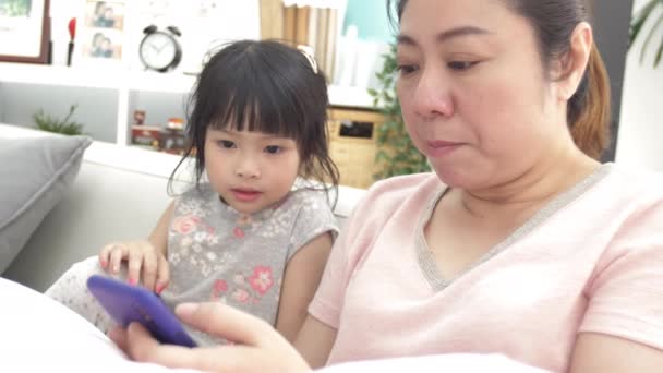 快乐的亚洲家庭母亲和女儿看着电话和扩大与微笑的脸 — 图库视频影像