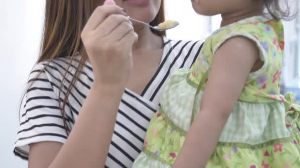 Gülümseme Yüz Ile Evde Kızı Için Yemek Besleyen Asyalı Anne — Stok video