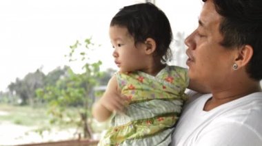 Genç bir baba ortaya çıkar ve küçük kızını açıklar. Baba evde çocuğuyla oynuyor..