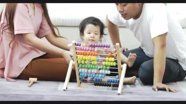 家庭夫妇妈妈和爸爸玩与小女孩在房间里的地板上 年轻的父母有乐趣的休闲时间在一起小女儿 — 图库视频影像