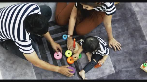 家庭夫妇妈妈和爸爸玩与小女孩在房间里的地板上 年轻的父母有乐趣的休闲时间在一起小女儿 — 图库视频影像