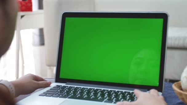 緑色の画面を見ているアジアの女性の肩のショットの上に ラップトップグリーンスクリーン 4Kドリーショットでラップトップコンピュータを使用してオフィスの人 — ストック動画