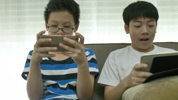 在智能手机上玩游戏的年轻亚洲男孩 — 图库视频影像
