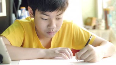 Çocuk ödev yazıyor. Çocuklar oturma odasında masada ev işleri yapmak