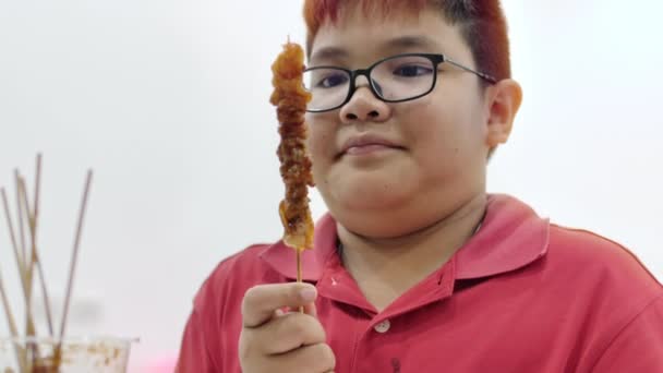 男孩喜欢吃烤猪肉与微笑的脸在家里 — 图库视频影像