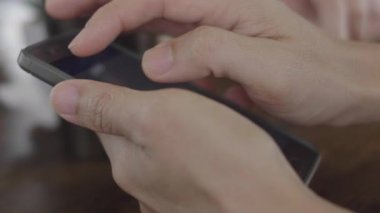 Akıllı telefon ile adam ellerin yakın çekim . Teknoloji, akıllı telefondan haber alan genç bir adamın elleri.