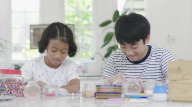 Genç asyalı erkek ve kız gülümseme yüzü ile yapboz ile oynuyor. Ev el sanatları. Dolly atış 60fps.