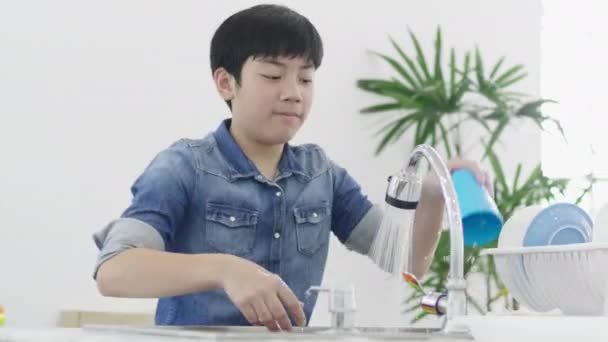 亚洲小男孩在家厨房洗菜 生活方式概念 青少年洗碗在水槽在现代房子在泰国 60Fps — 图库视频影像