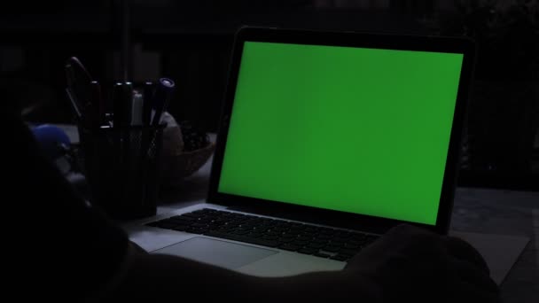 带绿屏的笔记本电脑 黑暗的办公室完美的放置自己的图像或视频 正在使用的技术的绿屏 色度键笔记本电脑 — 图库视频影像