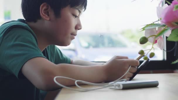 Ασιατικό Νεαρό Αγόρι Απολαμβάνοντας Παιχνίδι Στο Touch Pad Στο Καφέ — Αρχείο Βίντεο