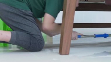 Yakın Asya genç çocuk bir paspas kullanarak ev temizliği aile yardım. 