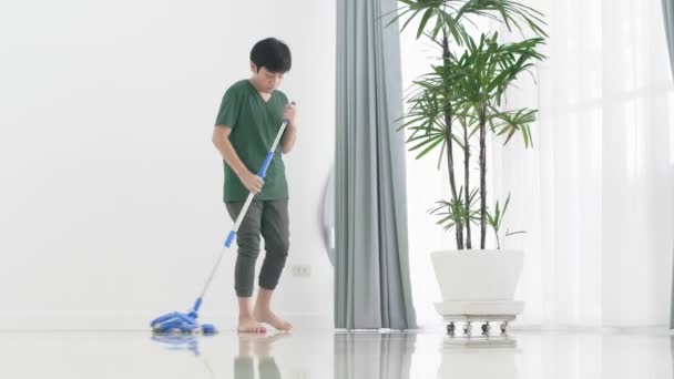 特写亚洲小男孩帮助家庭用拖把打扫房子 — 图库视频影像