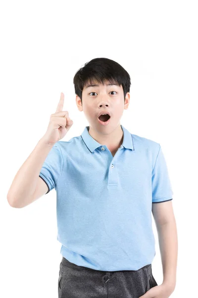 Młody azjatycki chłopiec myśli i wskazuje w górę, uśmiechając się . — Zdjęcie stockowe