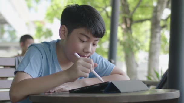 Lindo Asiático Chico Usando Tableta Ordenador Joven Adolescente Haciendo Tarea — Vídeo de stock