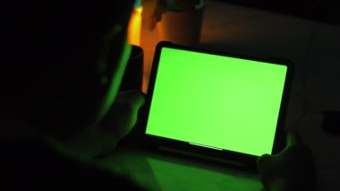 Tablet bilgisayar kullanarak Asya adam omuz görünümü üzerinde . Yeşil ekran teknoloji kullanılıyor. Renk Anahtar tablet.