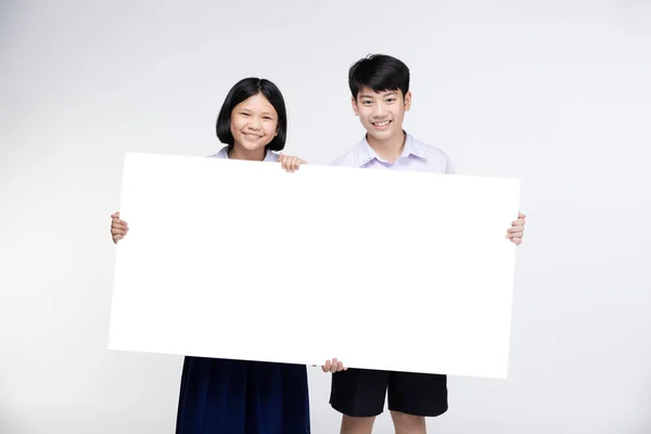 Cute Asian kids in student's uniform with white board. — Stock Photo, Image