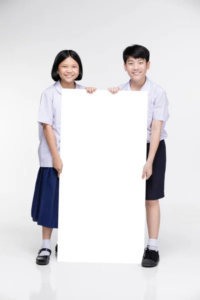 Милые азиатские дети в студенческой форме с белой доской . — стоковое фото