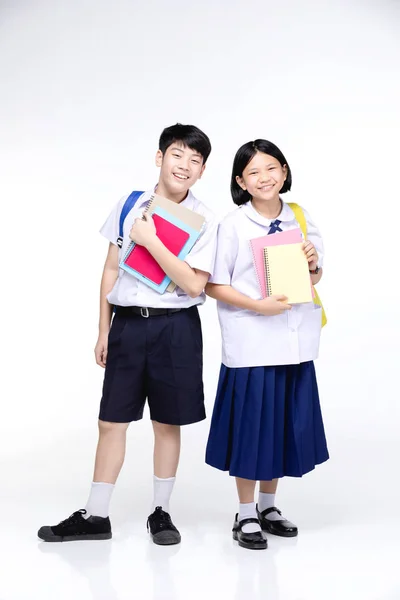 Двоє азіатських усміхнених школярів з барвистим канцелярським приладдям , — стокове фото