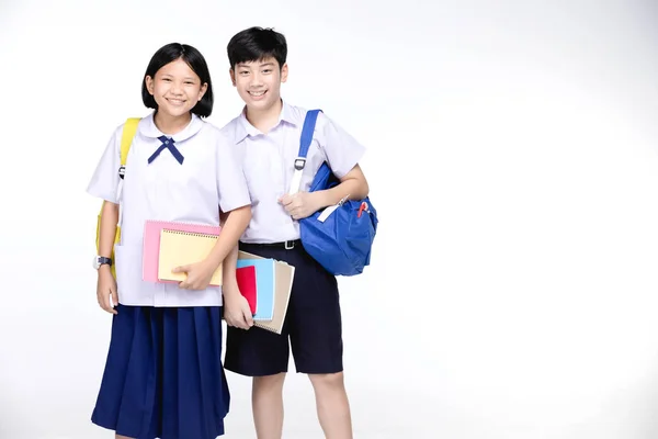 Два азиатских улыбающихся школьника с красочными канцелярскими принадлежностями , — стоковое фото