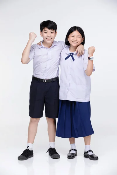 회색 배경에 학생의 유니폼에 아시아 소녀와 소년. — 스톡 사진