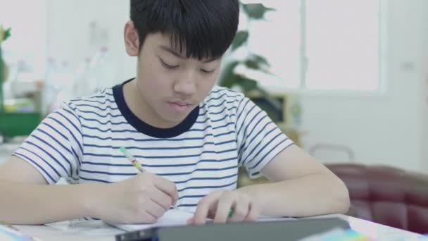 Asiatique Garçon Assis Sur Une Chaise Maison Faire Des Devoirs — Video