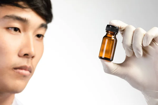 Asian scientist hand holding empty small brown medicine bottle . — Stock Photo, Image