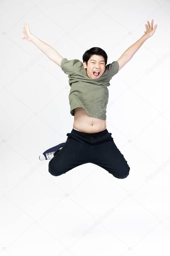 Portrait of happy little Asian child jumping isolated on gray