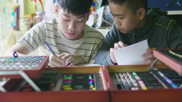 幸せな小さな男の子が宿題をしています 子供は家の机に座って宿題をしている 教育の概念 — ストック動画