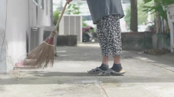 秋の散歩 公園でほうきで葉っぱを掃除する正体不明の女性 クローズ アップ — ストック動画