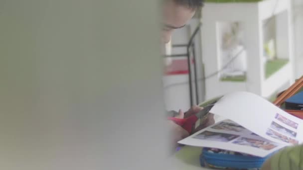 Азиатский Мальчик Вырезает Ножницы Бумаги Дома — стоковое видео