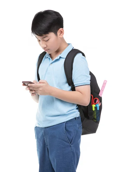 Μαθητής αγόρι με σακίδιο και επιστολόχαρτα κρατώντας κινητό τηλέφωνο . — Φωτογραφία Αρχείου
