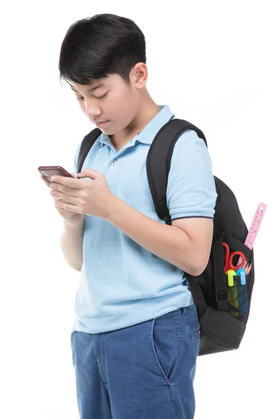 Uczeń chłopiec z plecaka i papeterii trzymając telefon komórkowy . — Zdjęcie stockowe