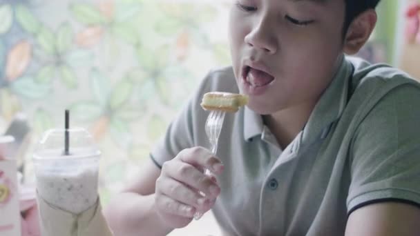 幸せなアジアの男の子は笑顔で自宅で食べて楽しむ — ストック動画
