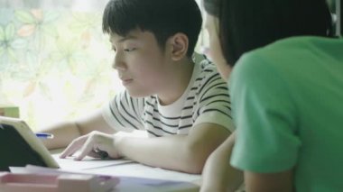 Asyalı çocuk tablet bilgisayar ile ev ödevi yapıyor,Teenage Boy Eğitim Evde Dijital Tablet Kullanarak arkadaşı ile.