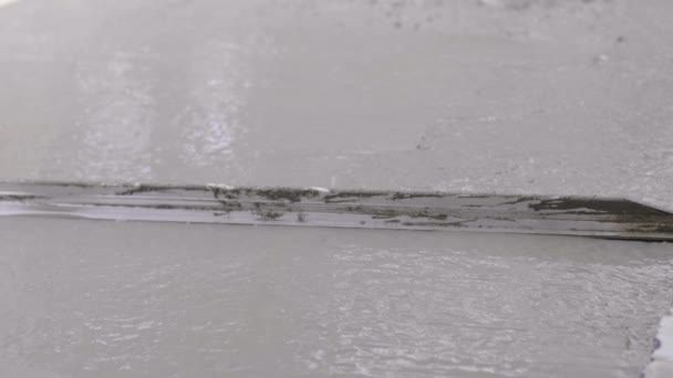 无名氏混凝土工人平滑湿路 浇注混凝土 一位工厂工人用铲子铲平和平整地板上潮湿的混凝土 — 图库视频影像