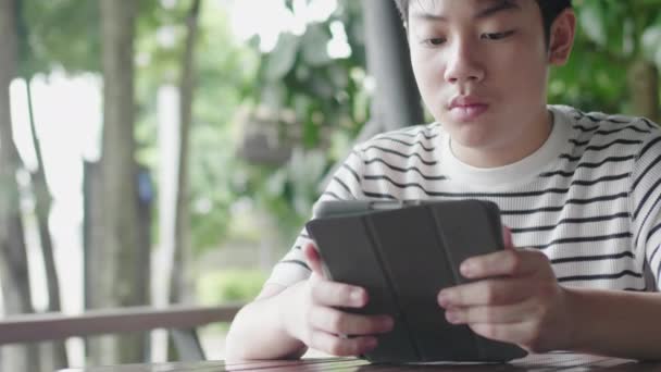 Aziatische Jongen Spelen Tablet Computer Met Glimlach Gezicht — Stockvideo