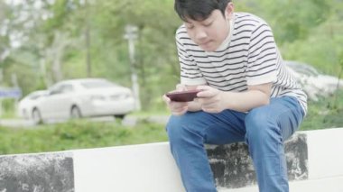 Heyecan dolu yüz ile yol yakınında mobil oyun Asya preteen çocuk oynuyor.