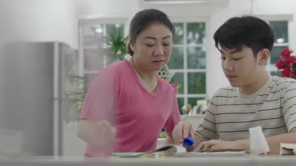明日先生を送るために息子が芸術をするのを手伝ってくれるアジアの母 — ストック動画